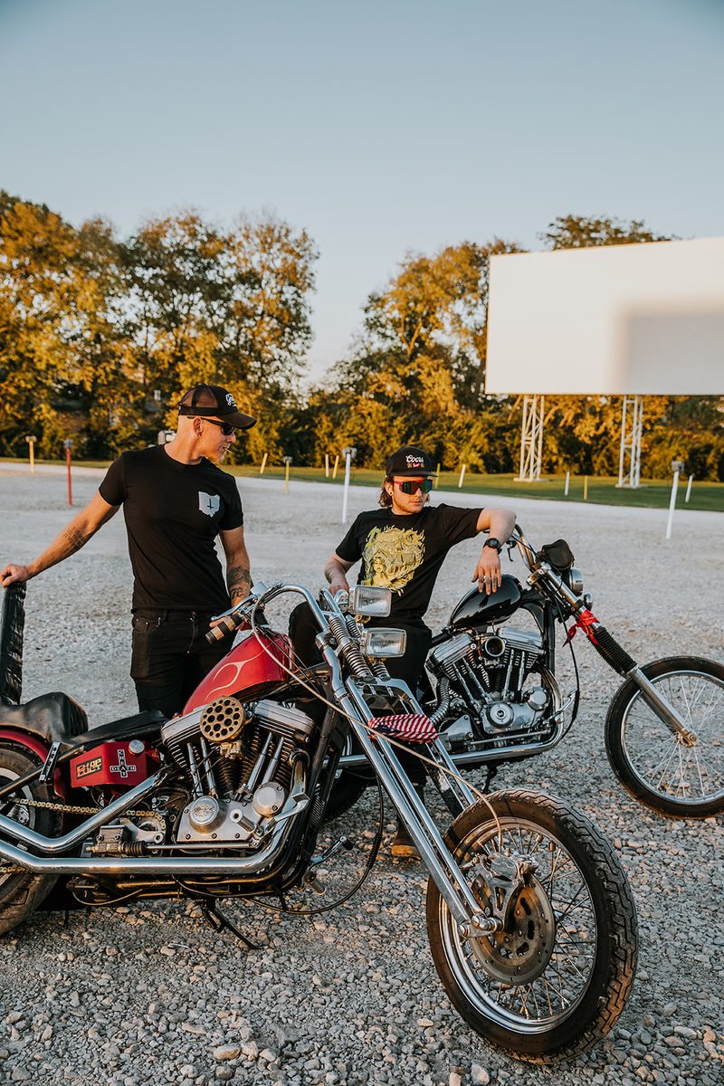 Jake and his son with two custom chopper motorcycles in a gravel lot